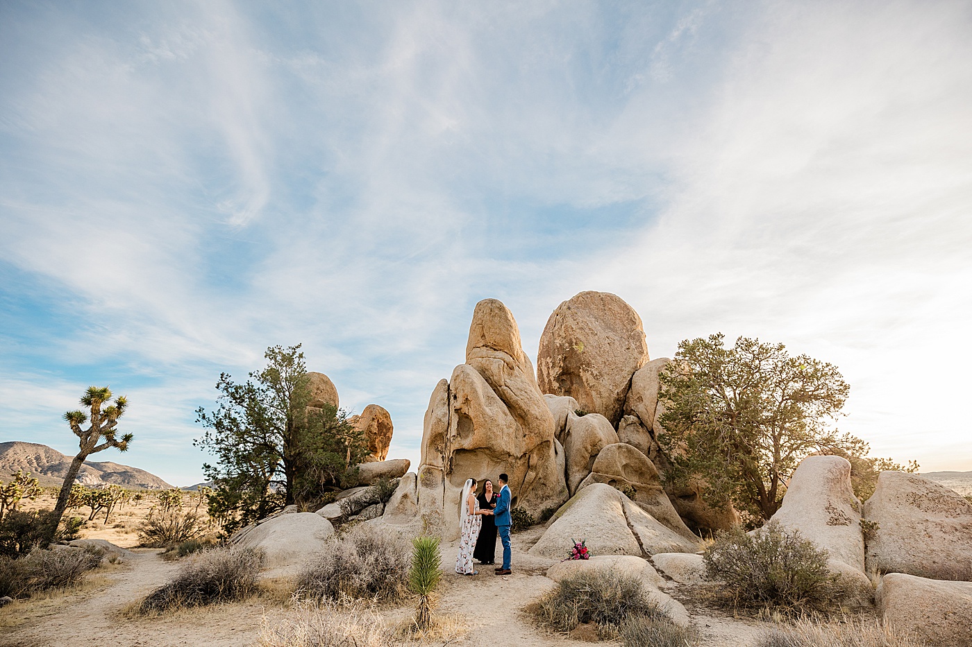 Joshua tree elopement ceremony with bride, groom and wedding officiant.