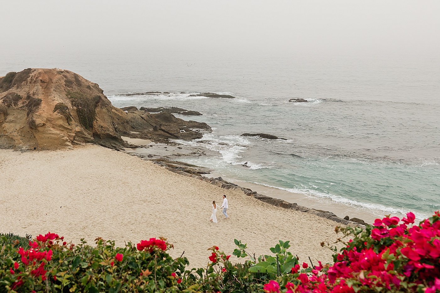 Bride and groom walk along the beach in SoCal beach elopement.