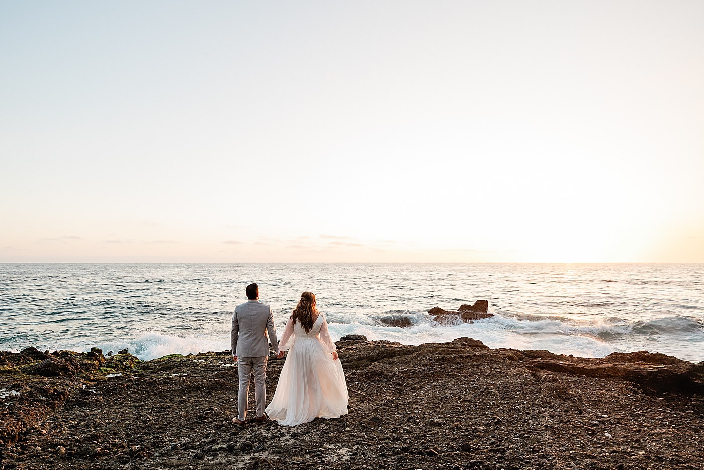 Bride and groom facing the sunset in Orange County elopement.