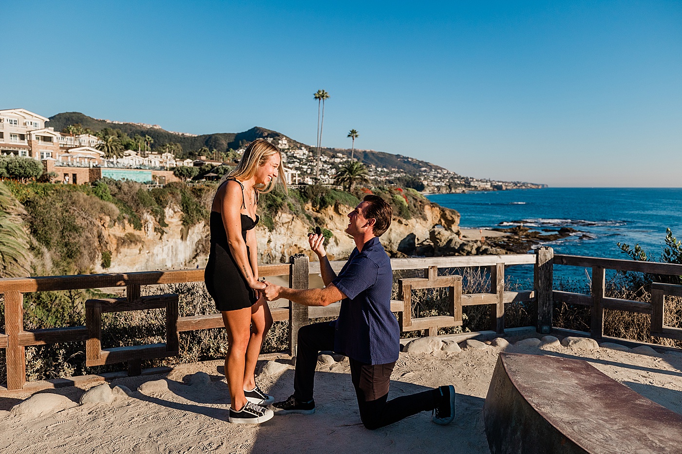 guy down on one knee to propose to his girlfriend at the montage